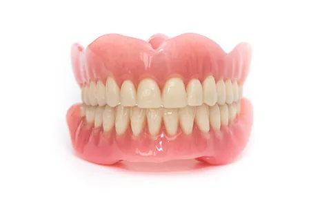 Vollständiger Zahnersatz mit Ober- und Unterkieferprothese aus rosa Kunststoff und weißen künstlichen Zähnen